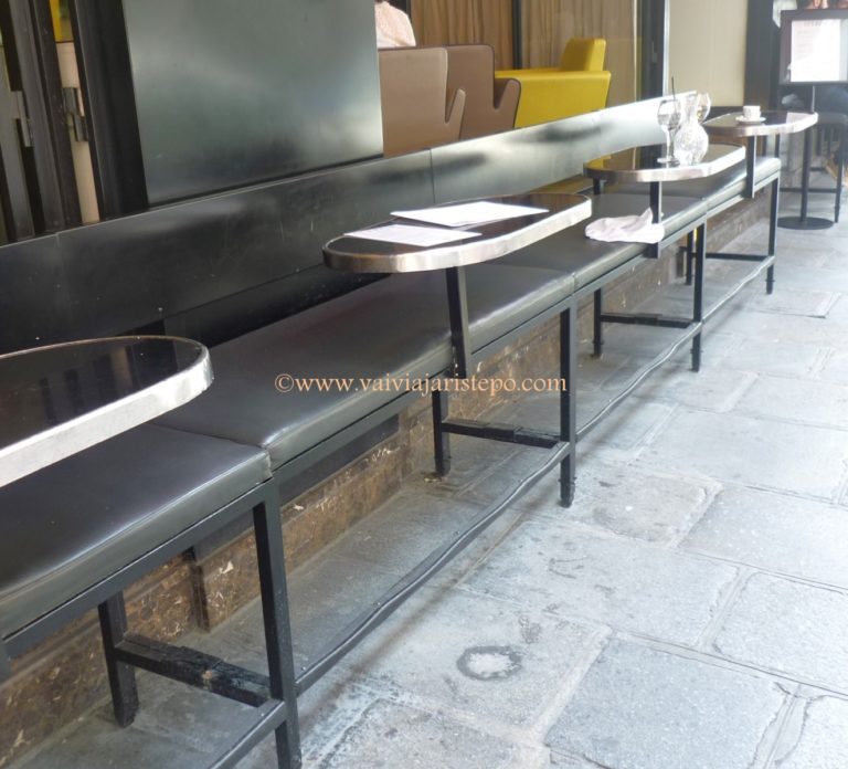 Mesas colocadas na calçada da rua de Buci. 