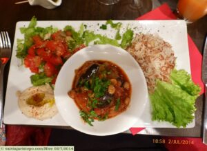 Composição deliciosa: pasta de grão de bico, tomates temperados, creme de berinjela defumada e azeitonas, arroz...