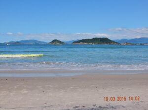 Finalmente Naufragados, nosso troféu. Ao fundo, à esquerda, a Ilha do Papagaio; à direita, a Ilha de Araçatuba, onde se encontra a Fortaleza de N. S. da Conceição.