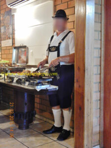 O alegre e simpático funcionário que servia as carnes de corte maior: pernil, carne assada e joelho de porco.