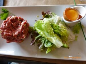 Steak tartar e salada verde. Prato de origem alemã adotado pela França, onde faz grande sucesso.