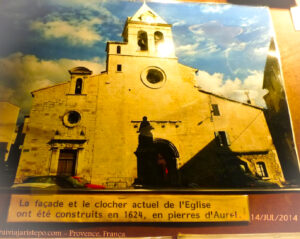 "A fachada e a torre sineira atual da Igreja foram construídas em 1624, em pedras de Aurel." Esta vila está situada na região de Sault, na fronteira do Vaucluse, departamento da Provence-Alpes-Côte d'Azur.