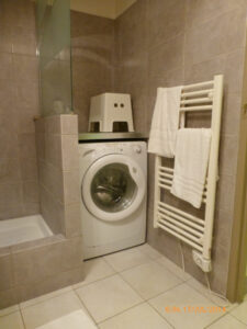 Esta máquina de lavar e o secador de parede ficam no banheiro, porque no apartamento não há área de serviço.